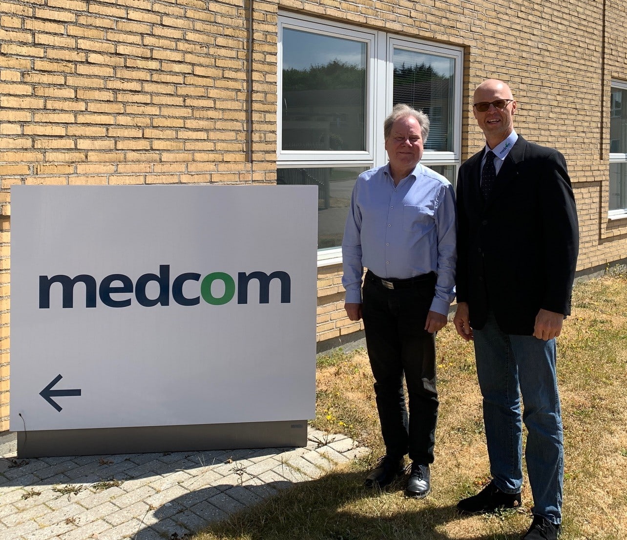 Kvalitetskonsulent Tomas og audittør Jens Lau foran MedCom-skilt i Forskerparken d. 7. juni 2023.
