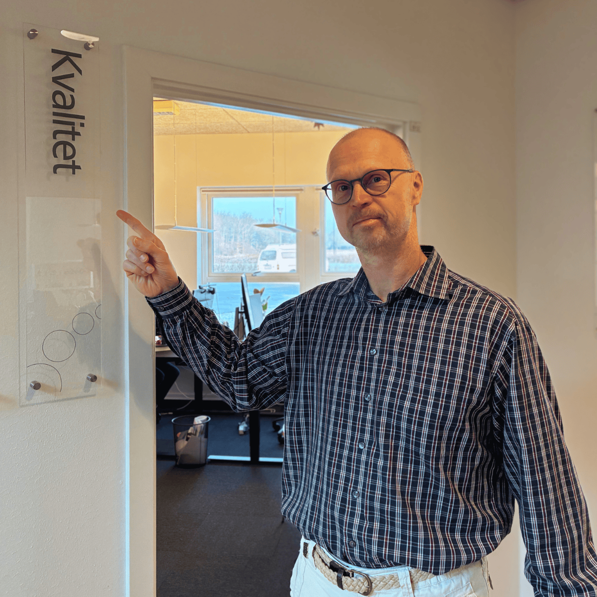 Billede af kvalitetskonsulent Tomas Placatka foran kvalitetsskilt i MedCom